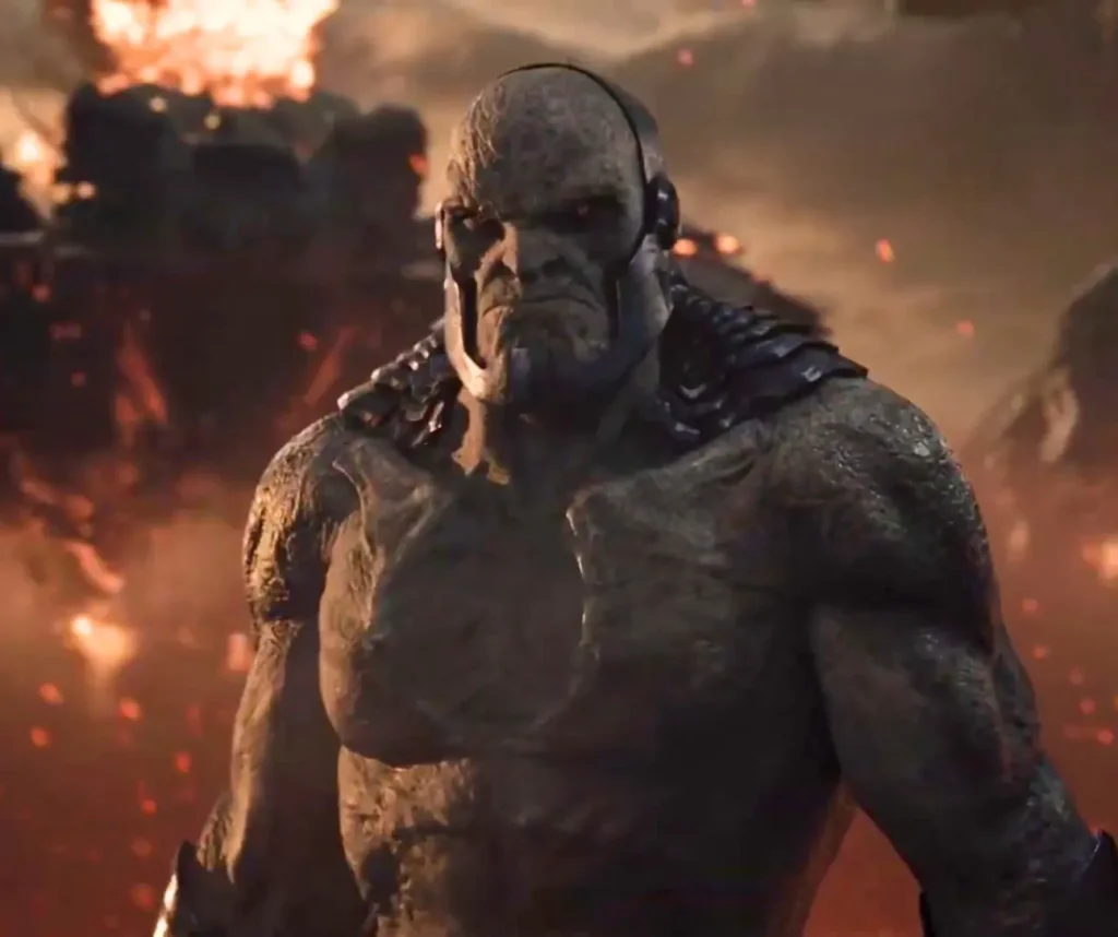 Darkseid's face in contemplative or speaking expression with glowing eyes against smoky battlefield