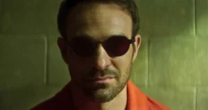 Matt Murdock in orange prison jumpsuit and red glasses smiling in cell in Daredevil Born Again Season 2 finale